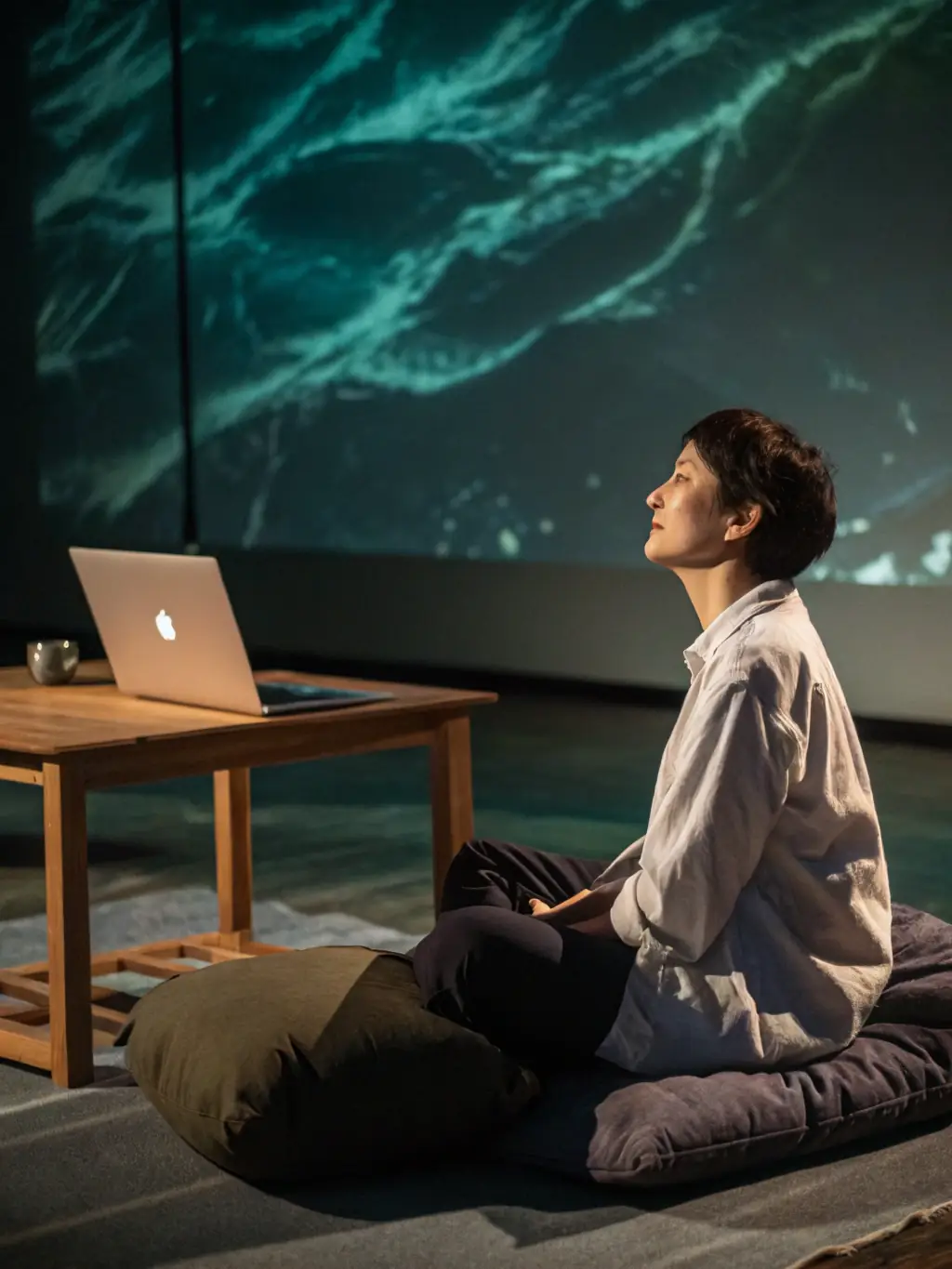 A serene image of a person meditating in a corporate office setting, symbolizing mindfulness at work. The person is sitting in a comfortable posture, with soft, natural light illuminating the scene, promoting a sense of calm and focus.